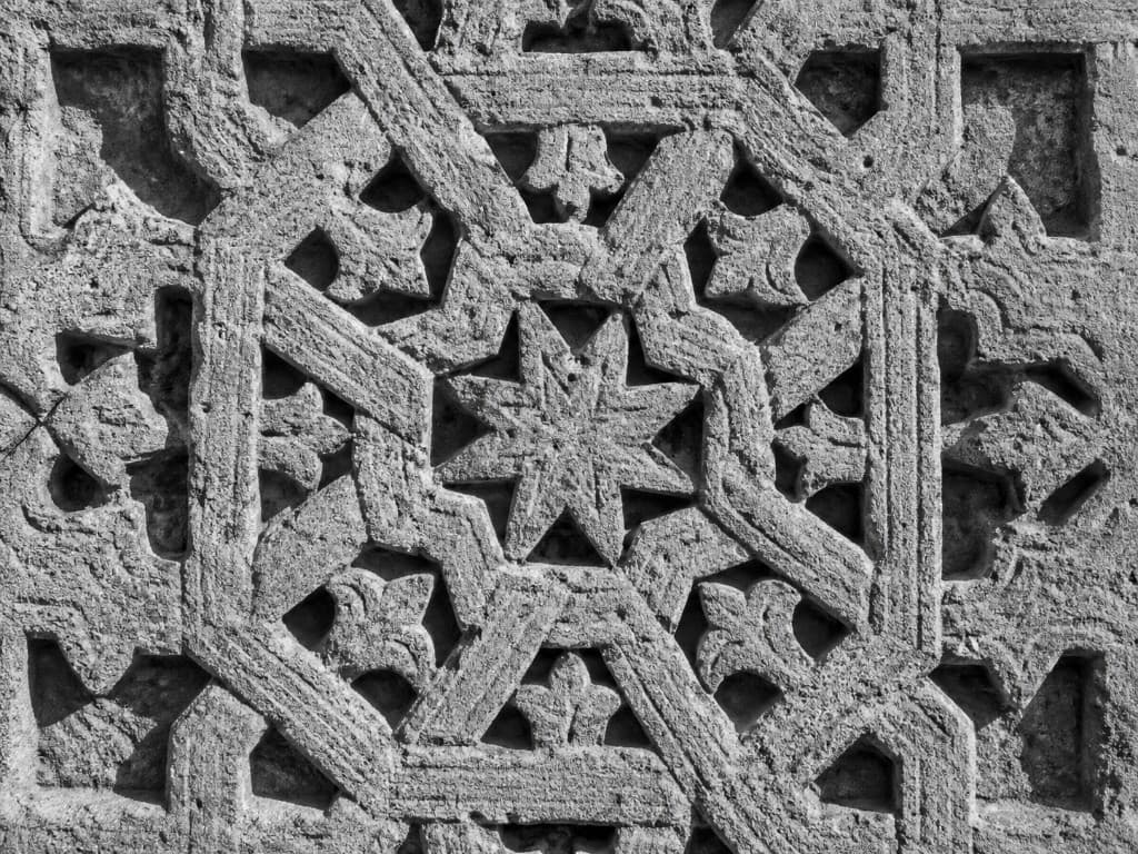Detail of a carved-stone geometric panel from a twelfth-century Ayyubid wall, eight-pointed star at the centre.